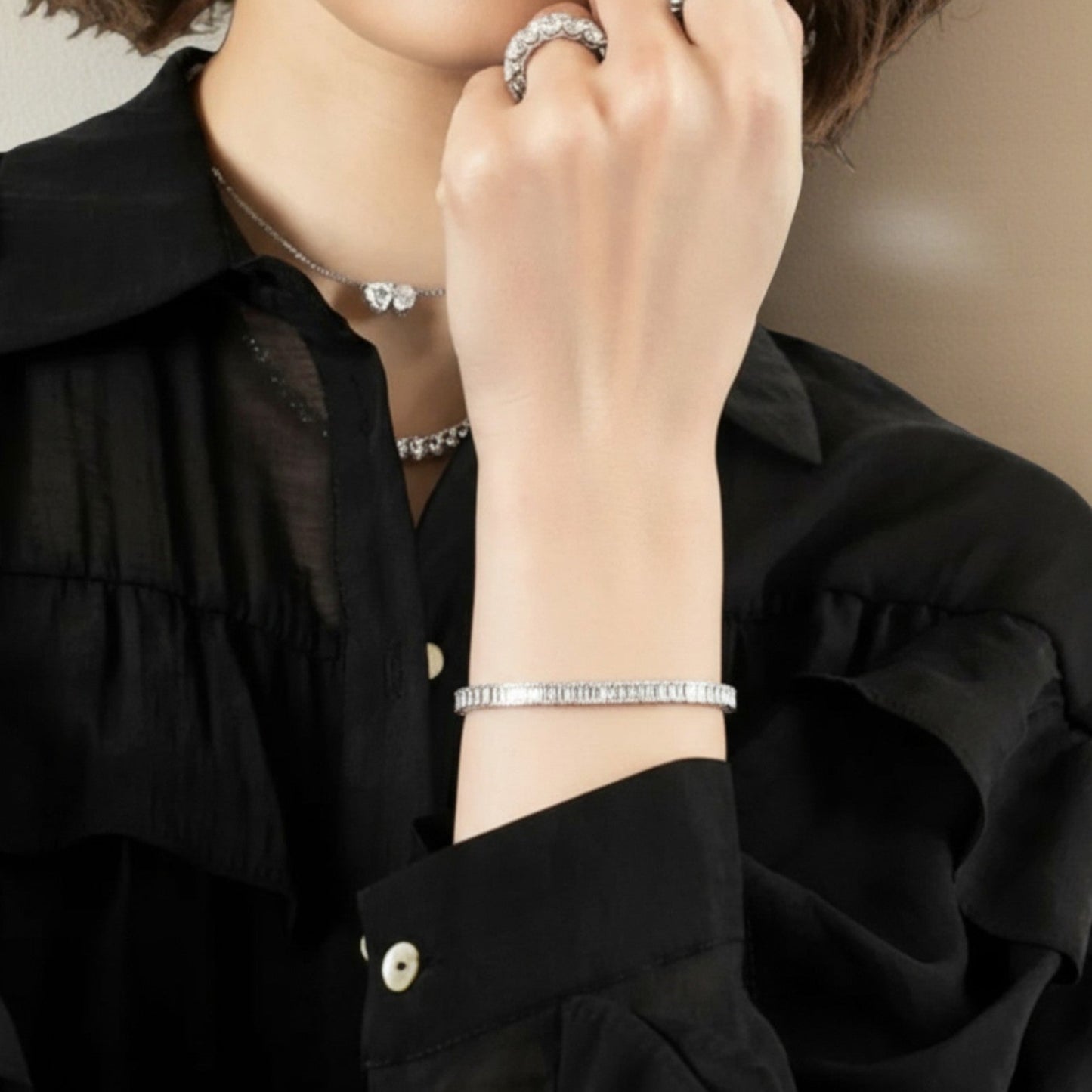 CHOE emerald bezel bracelet on a woman's writst - hero shot showing rectangular stone settings