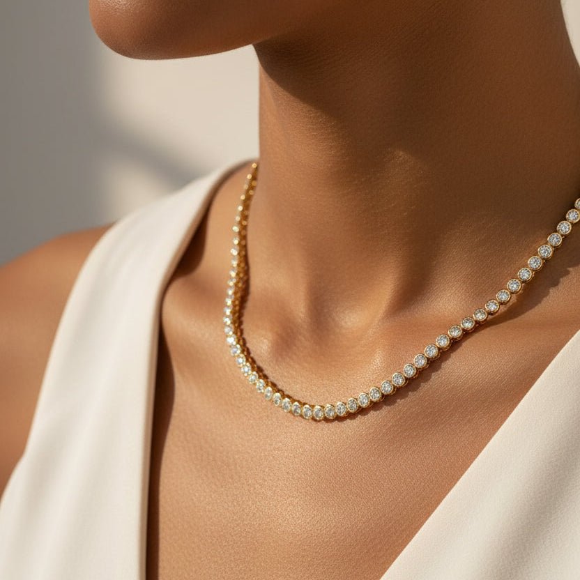 Tennis necklace with white cubic zirconia stones in gold vermeil worn by a woman with a neutral background
