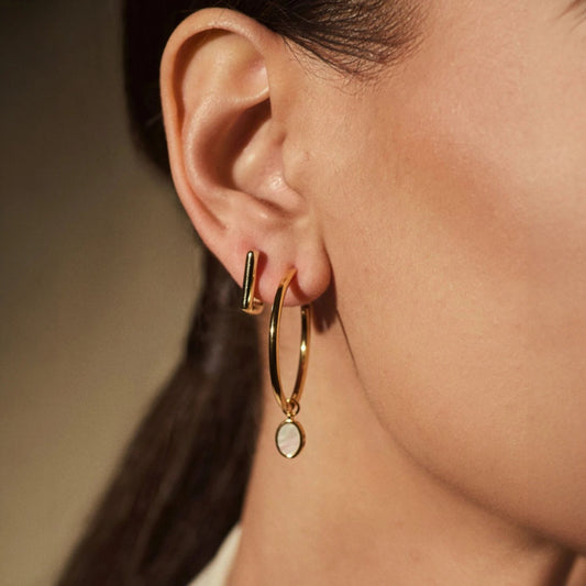 Woman wearing FYB Erin square gold huggie earrings