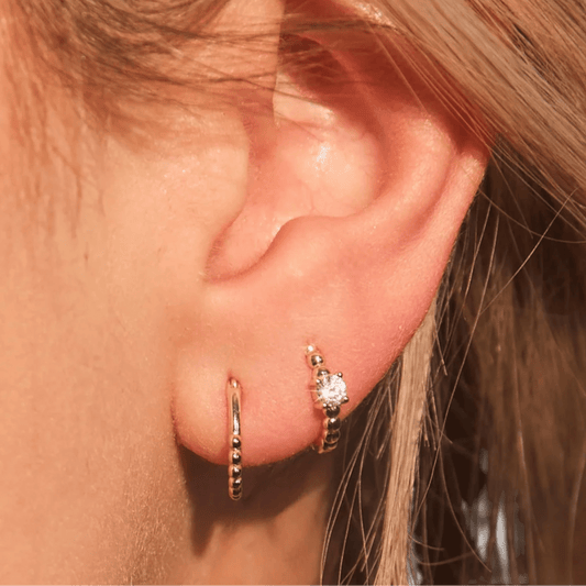 Woman wearing FYB Zia minimalist gold huggie earrings