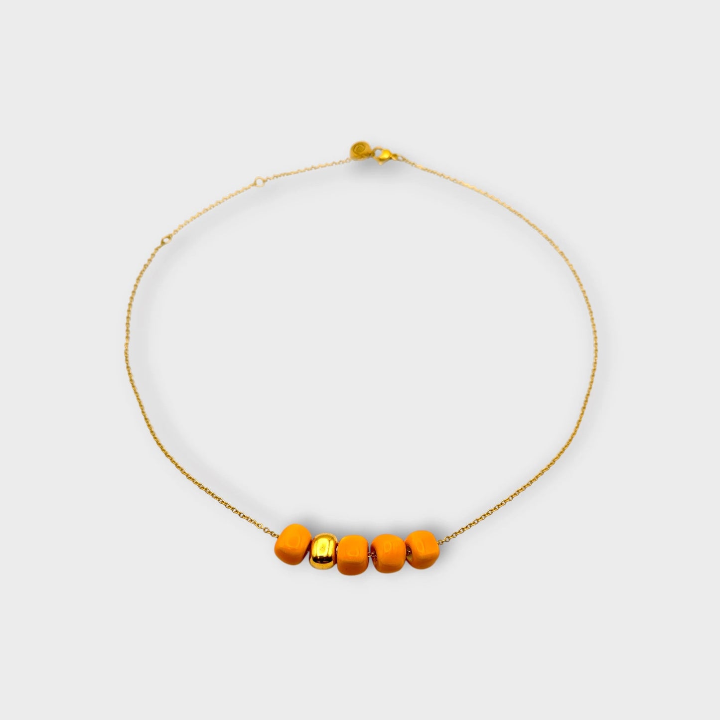 Maximilianas Cinco Cuentas necklace with four orange ceramic beads and one gold ceramic bead - product shot.