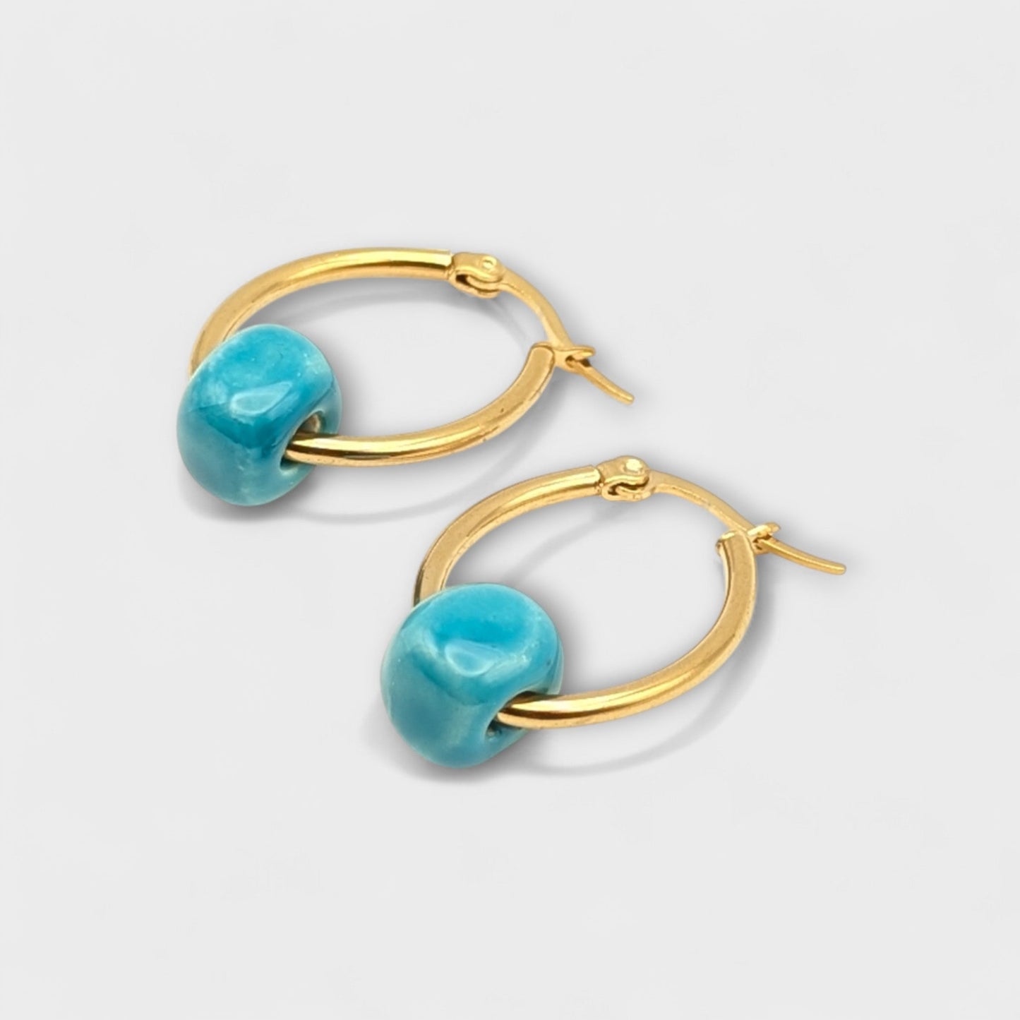 Maximilianas Cuenta oval hoops in 18K gold plated stainless steel and turquoise blue bead