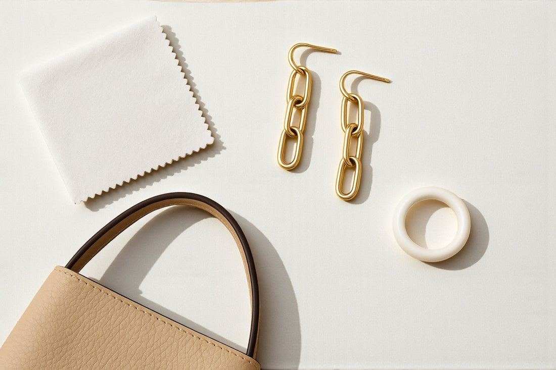 Flat lay image of a beige hand bag gold earrings cloth  