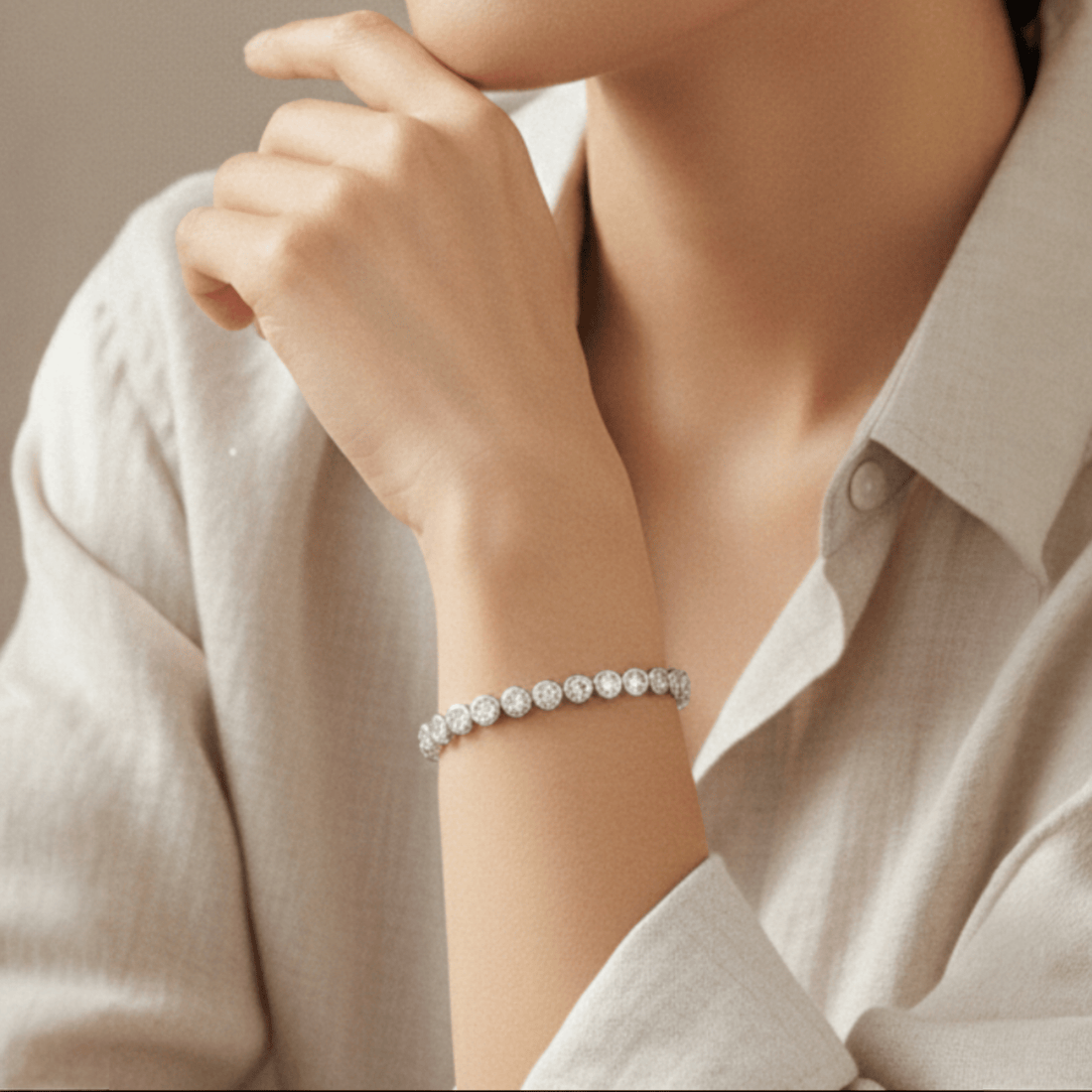 Woman's wrist with a tennis bracelet with stones set in round bezel in sterling silver