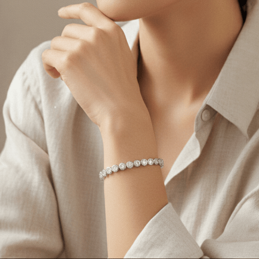 Woman's wrist with a tennis bracelet with stones set in round bezel in sterling silver