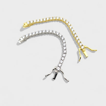 CHOE tennis necklace extenders, one gold and one silver, on a light gray background