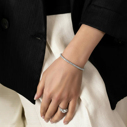 CHOE sterling silver tennis bracelet with round moissanite stones worn on woman's wrist