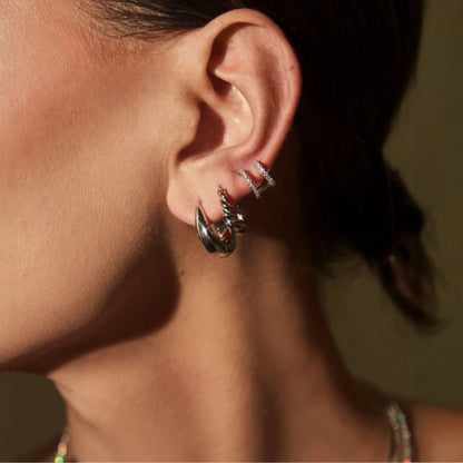 Close up of woman wearing FYB Delaney gold huggie earrings with pavé cubic zirconia stones
