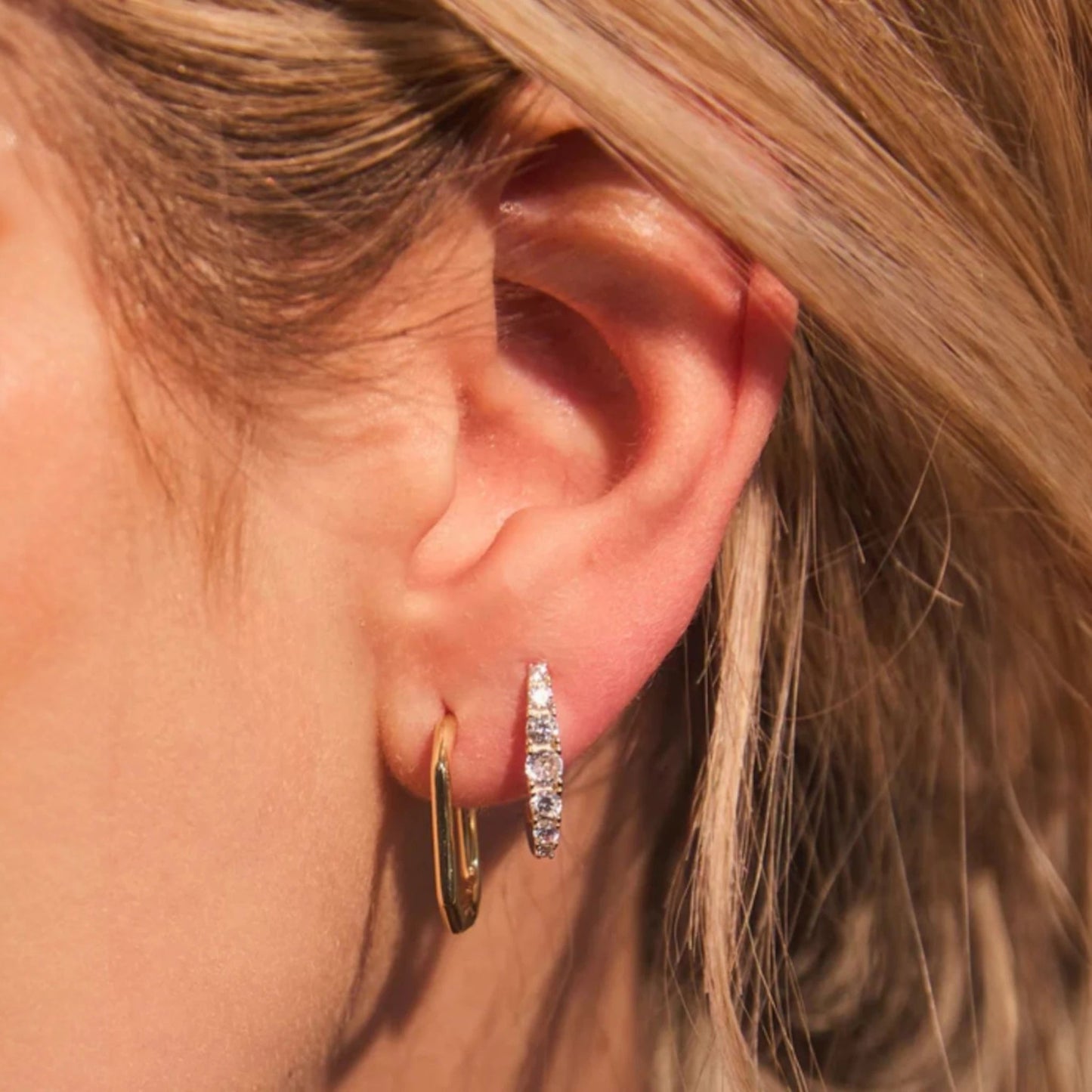 Woman wearing FYB Gianna gold huggie earrings
