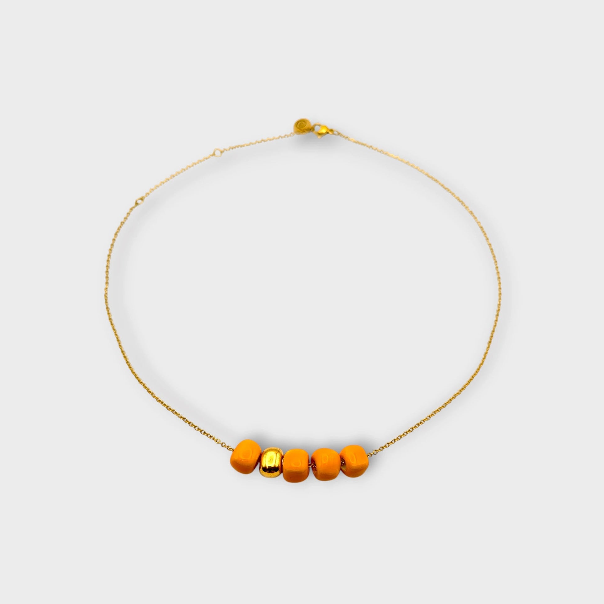 Maximilianas Cinco Cuentas necklace with four orange ceramic beads and one gold ceramic bead - product shot.