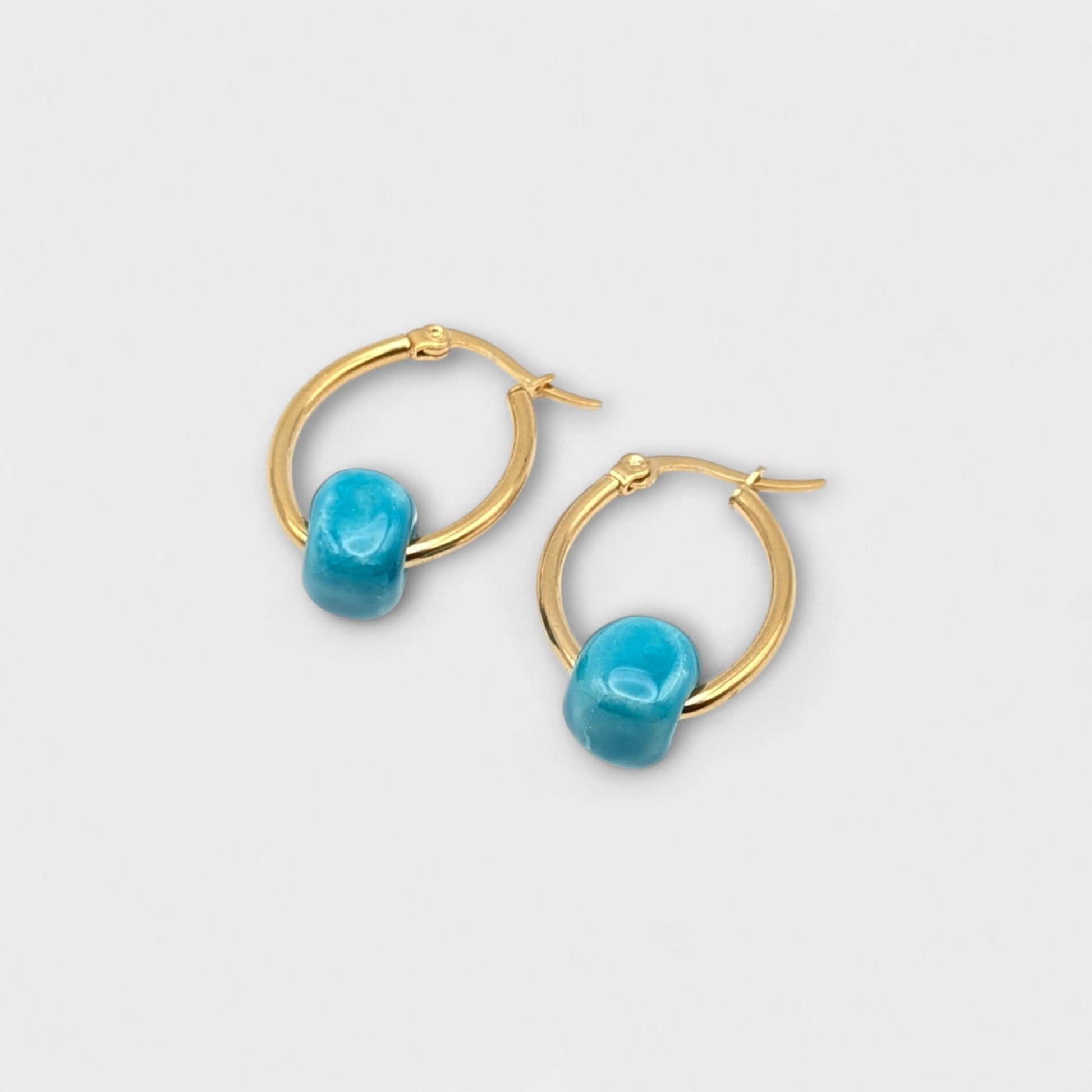 Maximilianas Cuenta oval hoop earrings with turquoise bead - close up