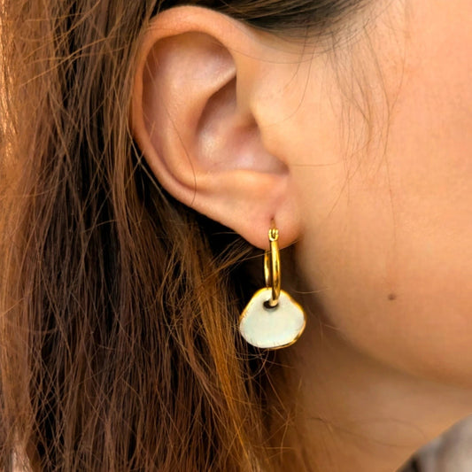 IRLÔH Maximilianas Ondulado Hoops: 18K gold plated stainless steel hoops with removable white ceramic pendant.