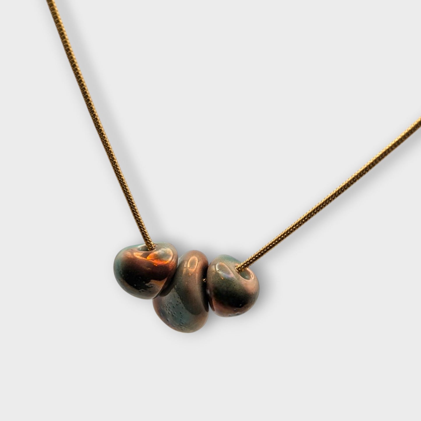 Close up product shot of Maximilianas Tres Petras necklace with three forest green ceramic beads 